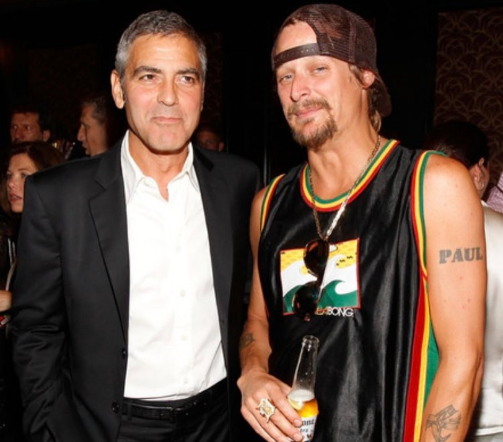 Kid Rock posing for a picture with George Clooney