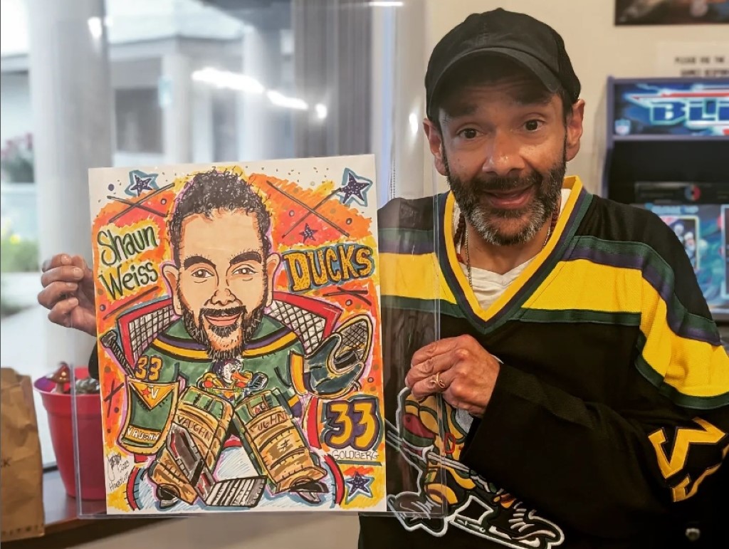 Shaun Weiss posing with his picture made by Mi Funko Pop in Ducks uniform