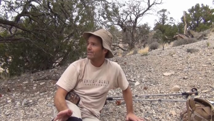 Kenny Veach sitting in a desert while he talks about his surrounding and findings