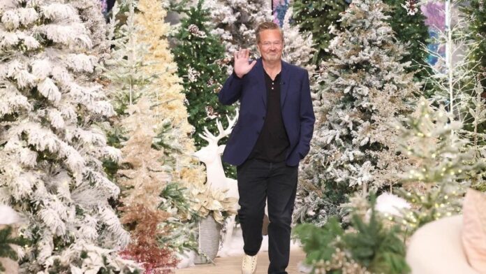Matthew perry walking by waving his hand