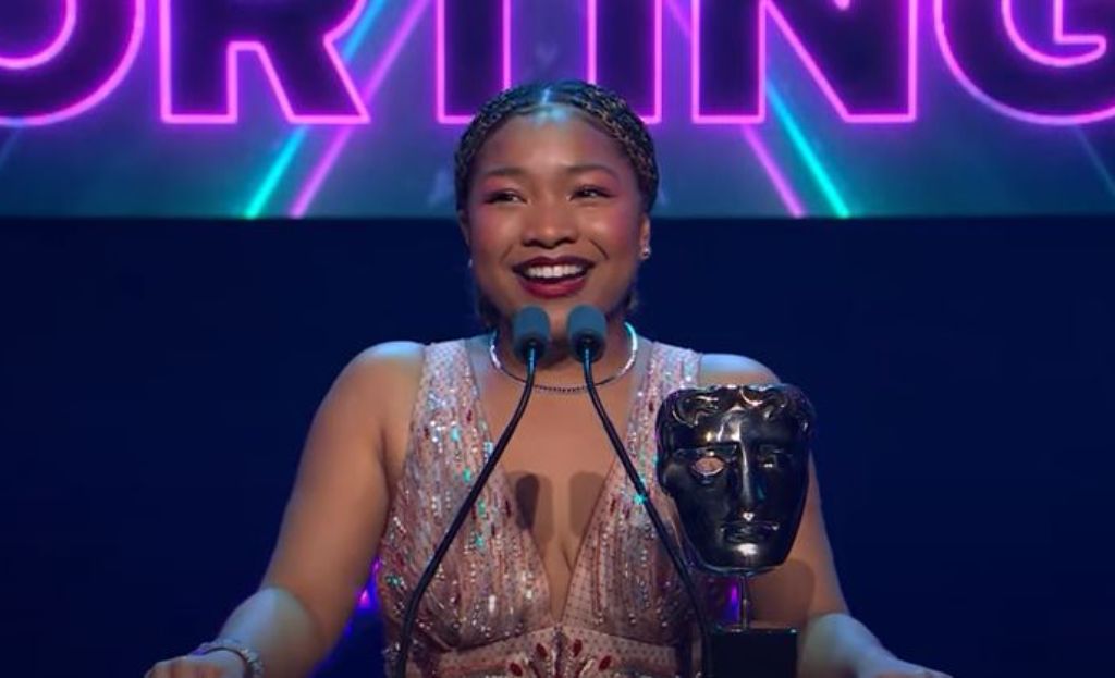Laya Deleon Hayes on the stage and holding BAFTA award.