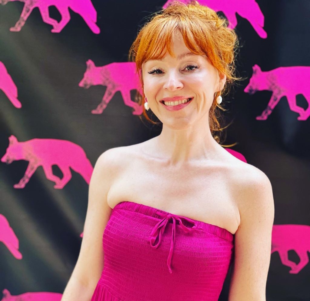 Ruth Connell in pink dress hair up 