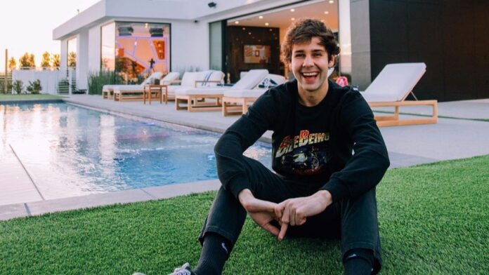 David Dobrik taking a picture in front of his new house