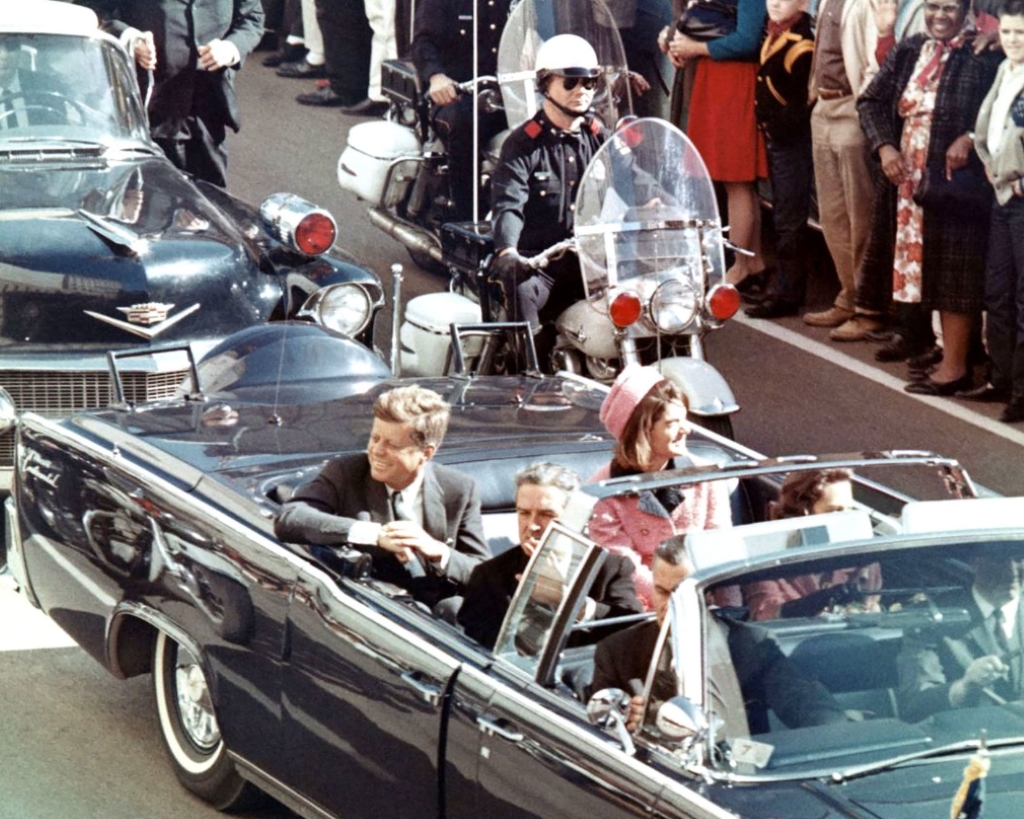 George Hickey walks behind JFK's limousine 