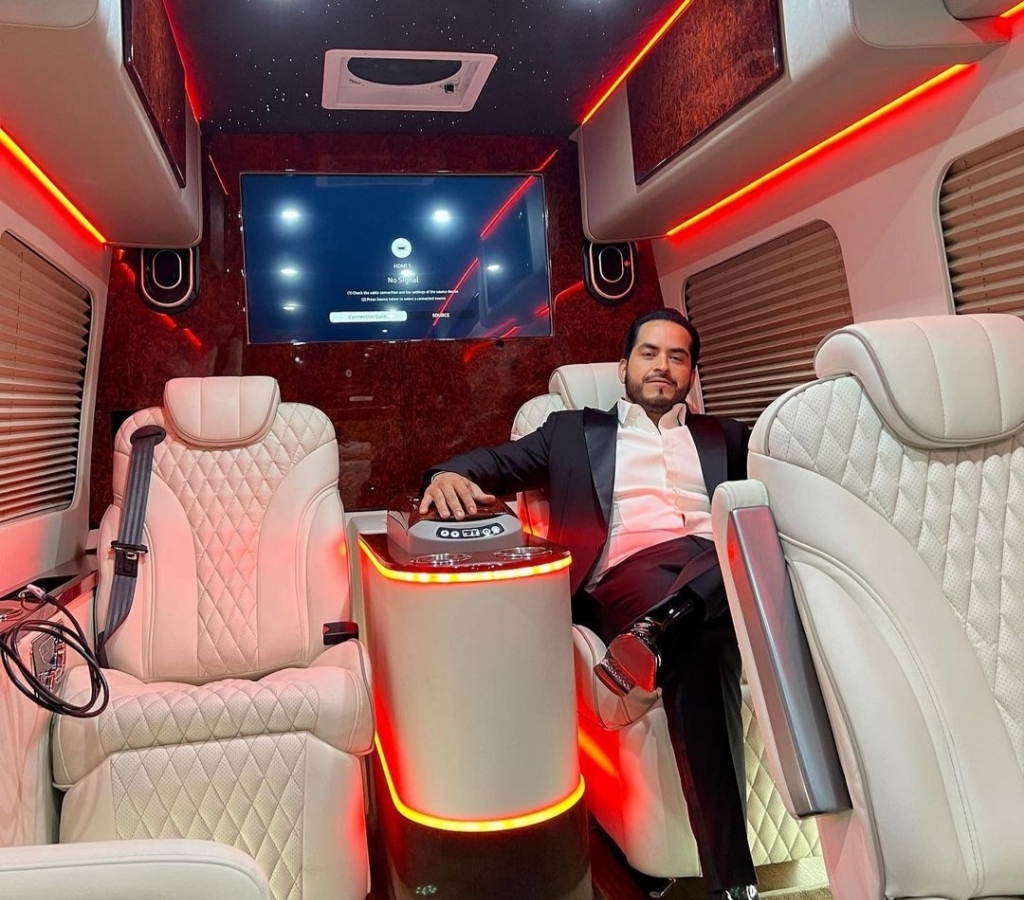 El Mago taking picture in a luxury vehicle