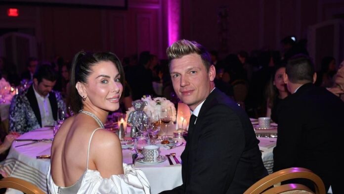 Lauren Kitt in white dress and Nick Carter in black suit together.