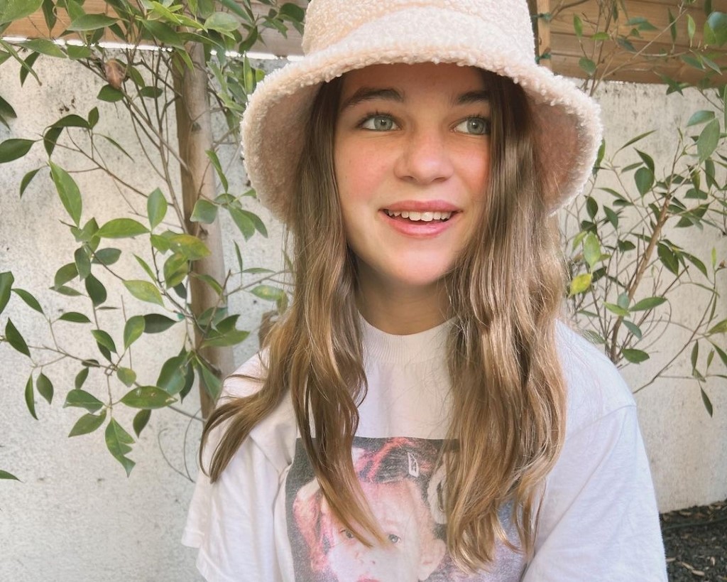 Raegan captured wearing a hat and white t-shirt.