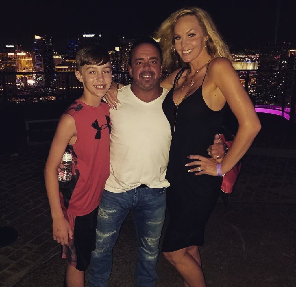 Shayna with her son and husband standing and smiling 