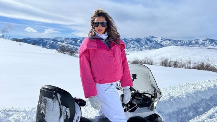 Katrina Campins in a snowy mountain wearing a red jacket.