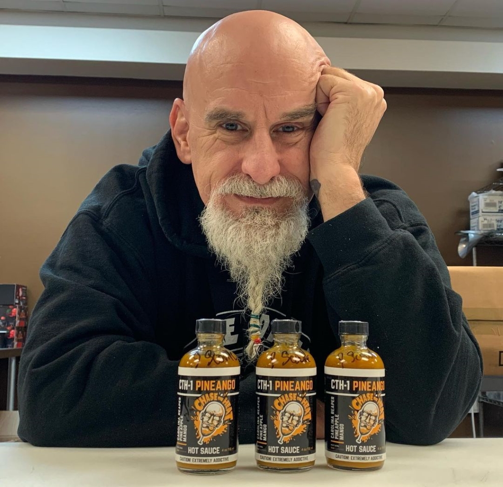 Johnny Scoville captured wearing a black hoodie with bottles of chili pepper. 