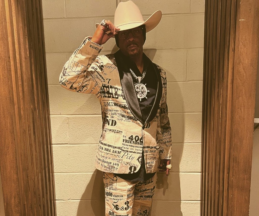 Katt Williams with a suit pant and a cowboy hat.