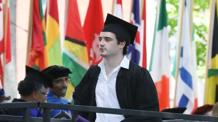 Liam Flockhart wearing graduation cap and gown and walking in crowd