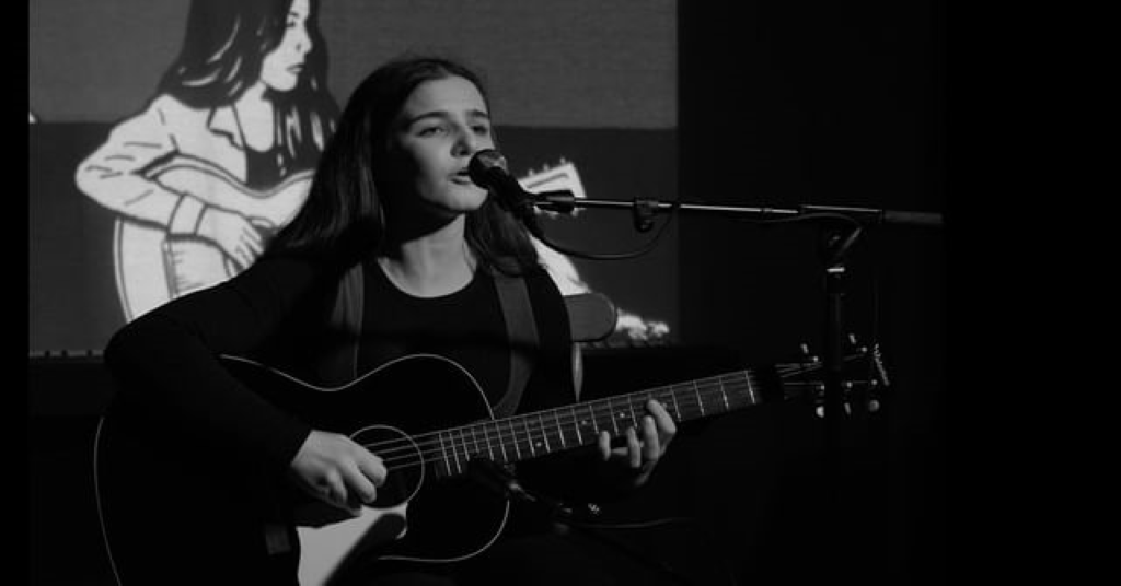 Muireann performing a cover song at her solo stage performance.