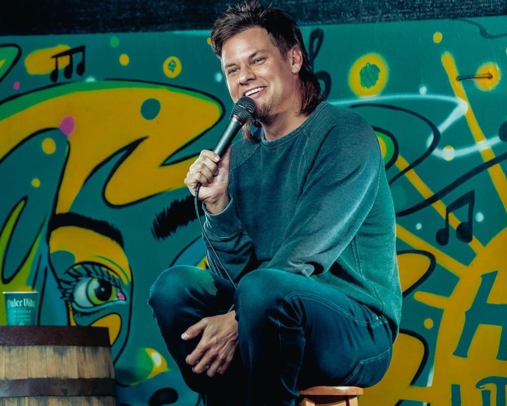 Theo Von captured during his standup show sitting in a tool.