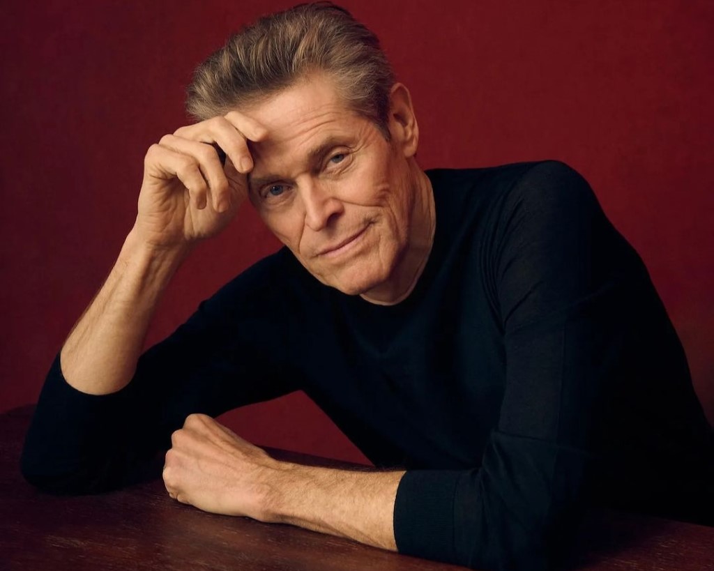 Willem Dafoe captured with his hand in his forehead. 