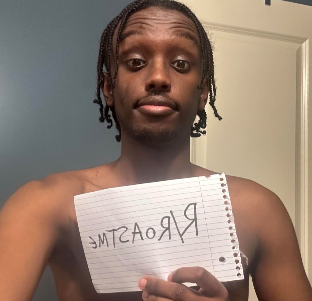 Yusuf7n without shirt holding a paper with roastme written on it 