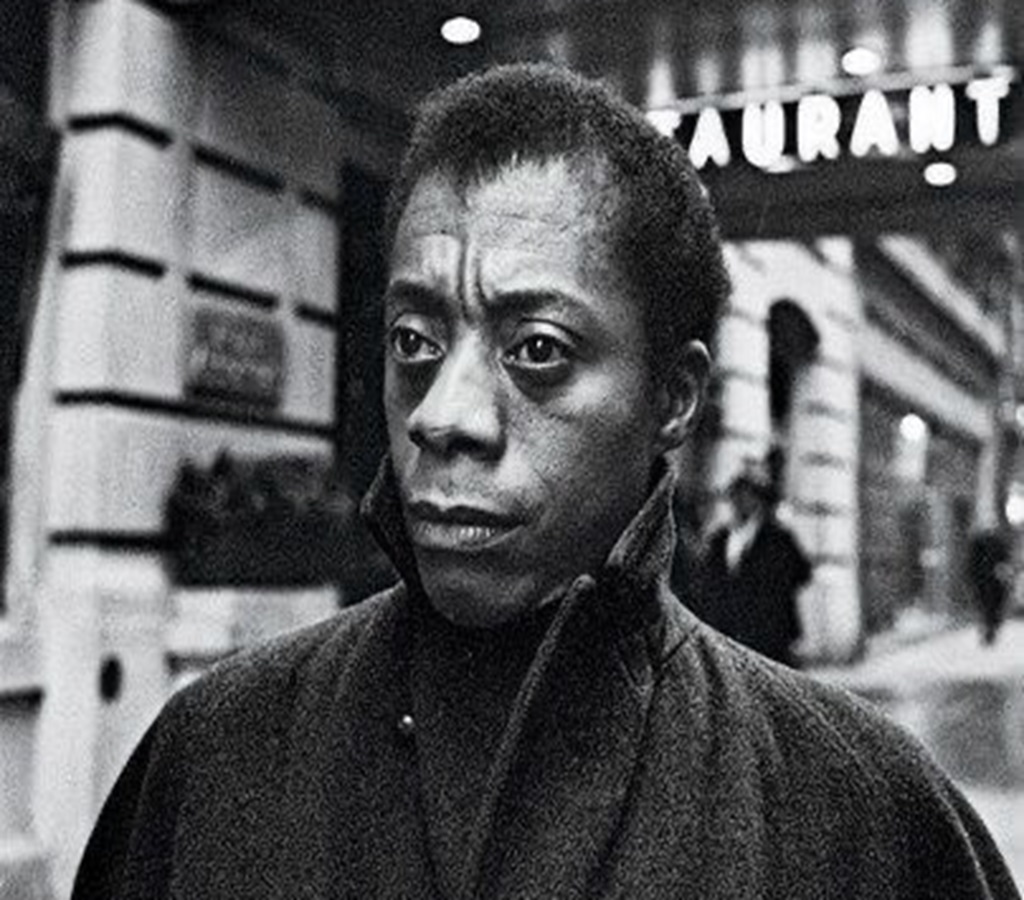 James Baldwin pictured in a black dress