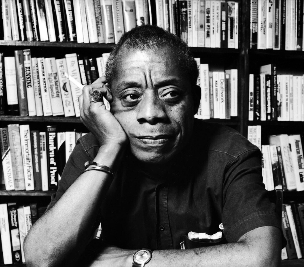 James Baldwin clicked in front of book shelf