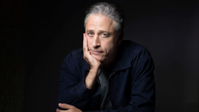 Jon Stewart in dark blue jacket