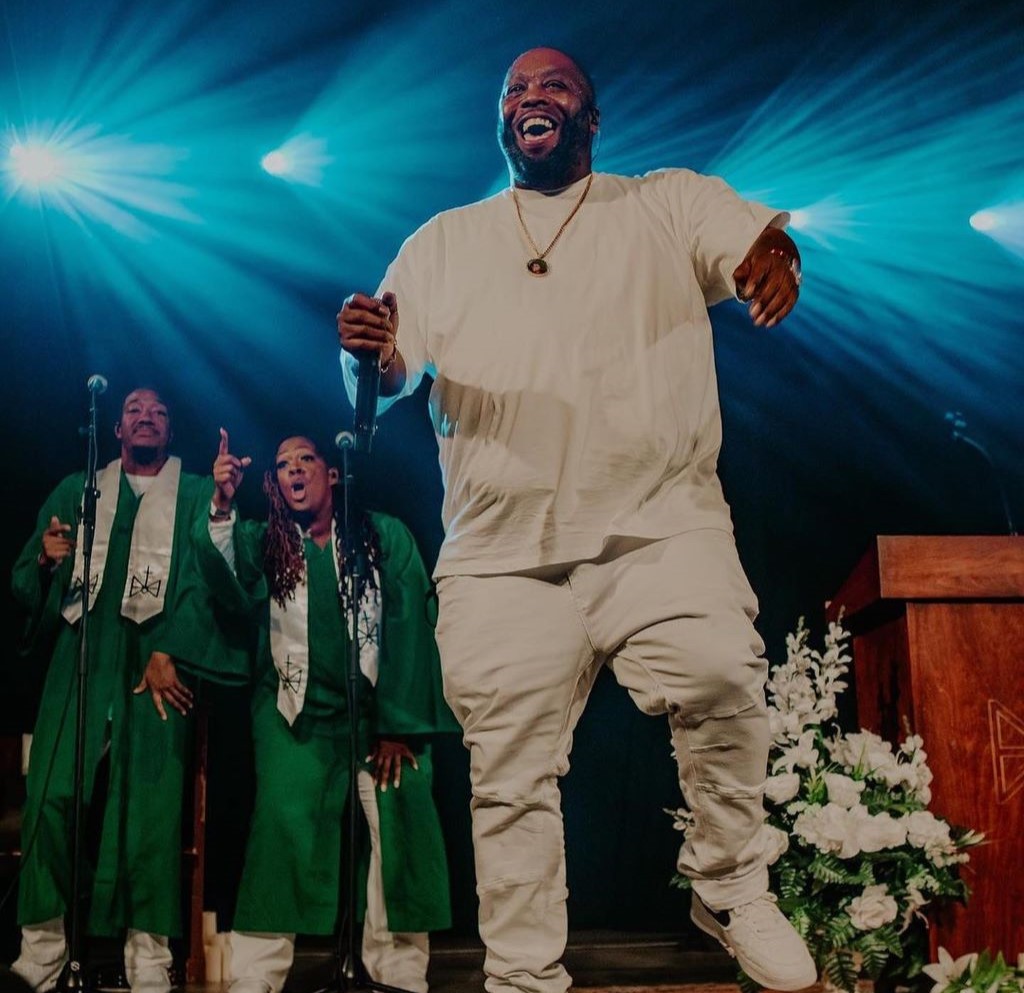 Killer Mike in all white laughing wide jumping 