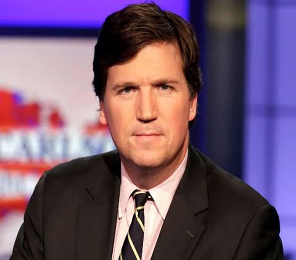 Tucker Carlson in a black suit and tie in the picture