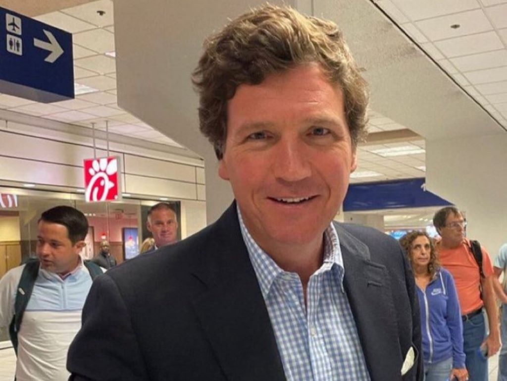 Tucker Carlson smiling in airport