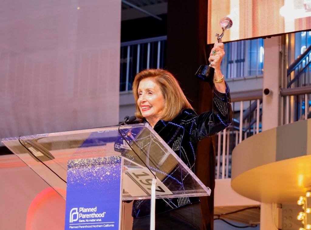 Nancy Pelosi giving a speech while holding an award.