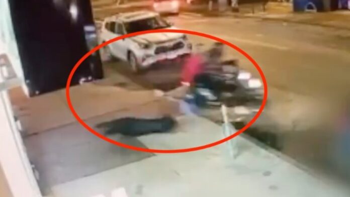 A woman is dragged by two robbers on a bike.